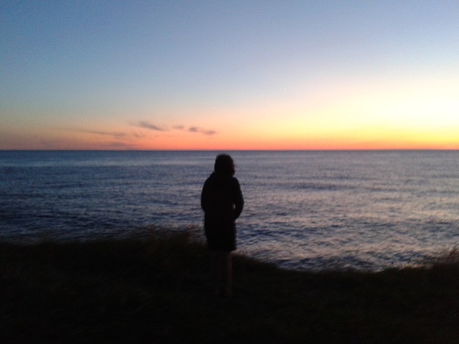 a person silhouetted by the sunset